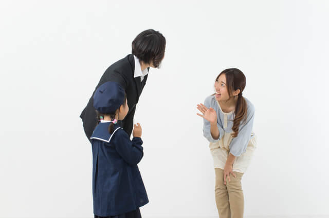 挨拶をする保育士と保護者,しつけ,