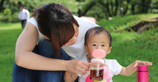マグでお茶を飲む赤ちゃん,