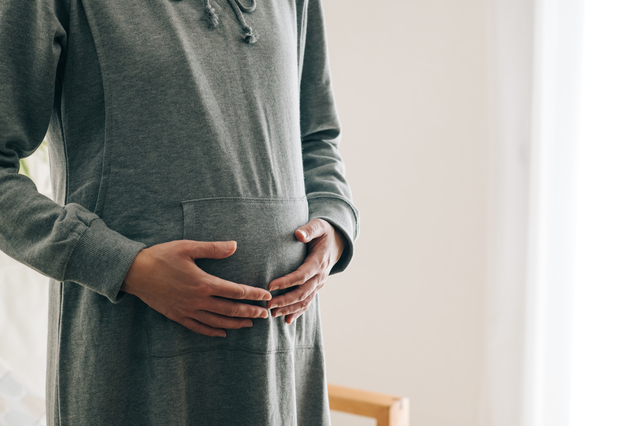 お腹を触る妊婦,マタニティボトムス,