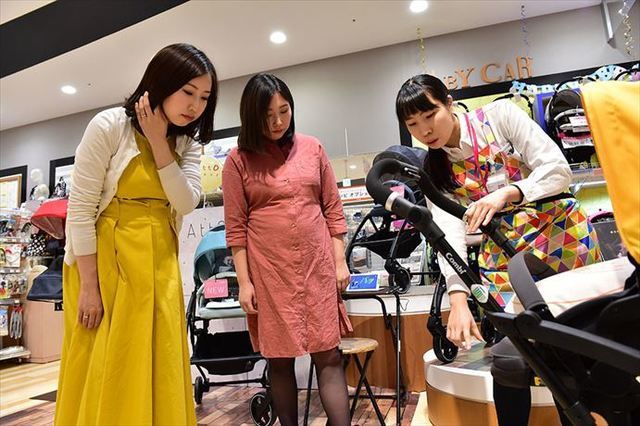 ベビーカーを見ながら説明を聞く女性たち,