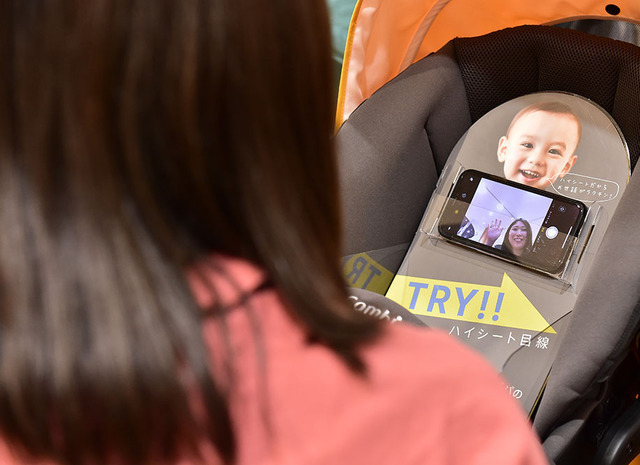 ベビーカーを見ながらモニターを見る女性,