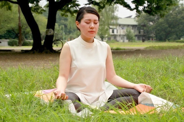 膝の上に手を置く女性,