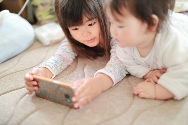 スマホを見ているこども photo-ac,絵本,読み聞かせ,