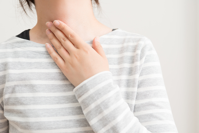 喉をおさえる女性,妊娠初期,喉の痛み,