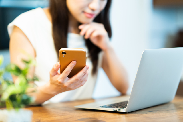 パソコンとスマホを見る女性,ベビー布団,