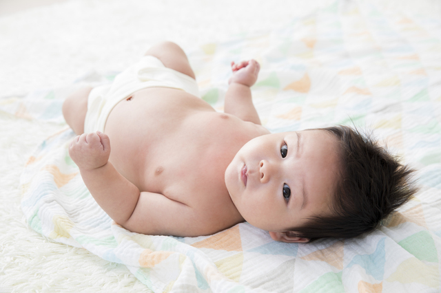 ガーゼ生地の上に寝る赤ちゃん,おくるみ,