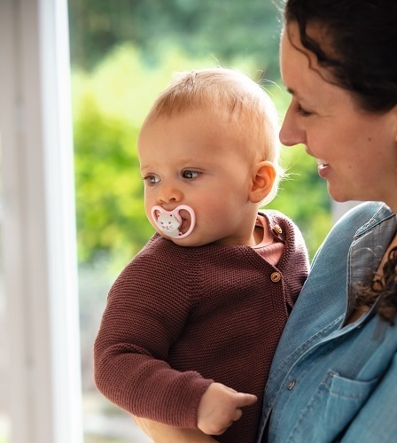 おしゃぶりをしゃぶる赤ちゃんとママ,