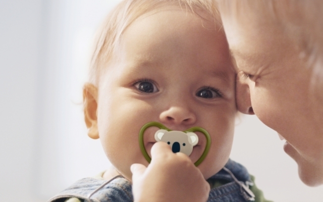 コアラデザインのおしゃぶりをしゃぶる赤ちゃん,