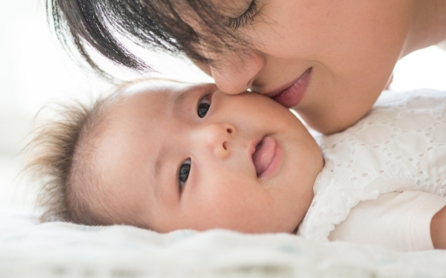 ママにキスされる赤ちゃん,