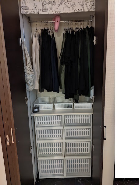 収納棚の中に突っ張り棒,タオル,