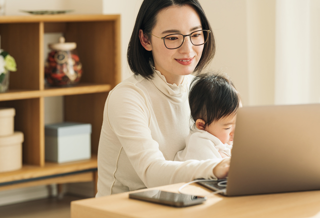 子どもを抱っこしながらパソコンを見る女性,車,修理,安い