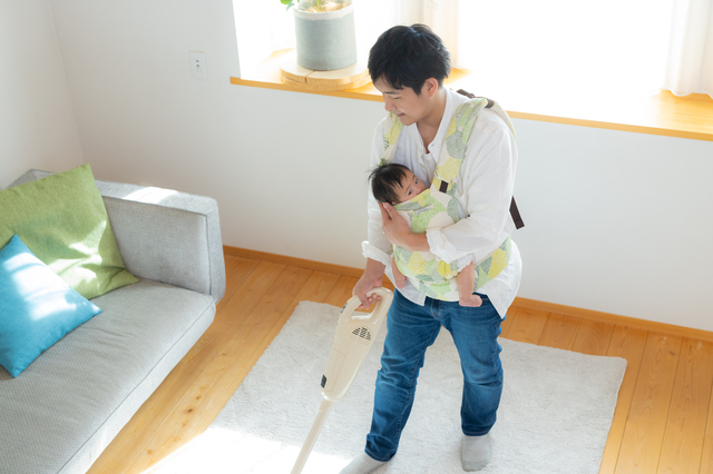 赤ちゃんを抱っこしながら掃除する男性,アンケート,夫婦仲,