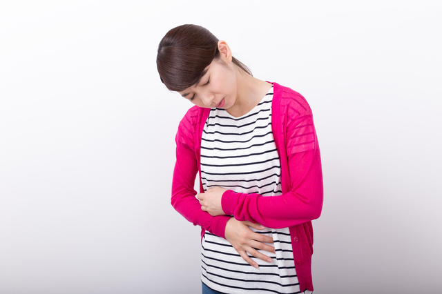 お腹をおさえる女性,妊娠,9週,症状