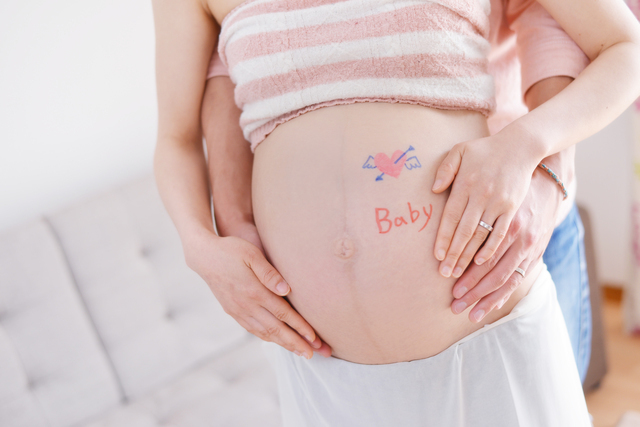 お腹に手をそえるママとパパ,妊娠22週,胎児,